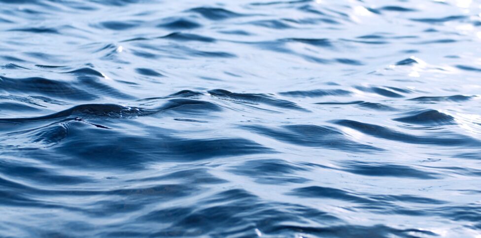 Calming image of undulating blue ocean waves reflecting sunlight, perfect for backgrounds.